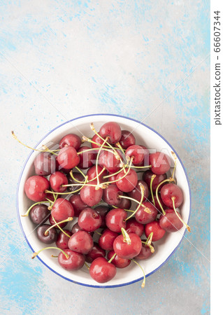 closeup wet cherry fruits on a white enamel plate 66607344