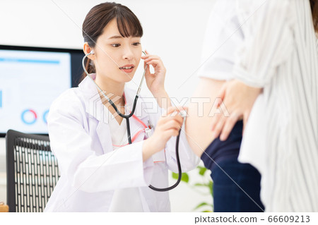 Doctor listening to the heartbeat of a pregnant woman's fetus Doctor listening to the heartbeat of a pregnant woman's fetus 66609213