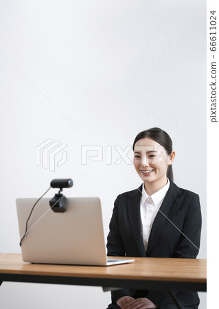 Online interview image Young woman in a suit talking to the webcam 66611024
