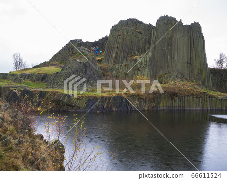 basalt pillars lava vulcanic rock formation organ shape with lake panska skala and group of tourist in blue jacket in kamenicky senov prachen czech republic 66611524