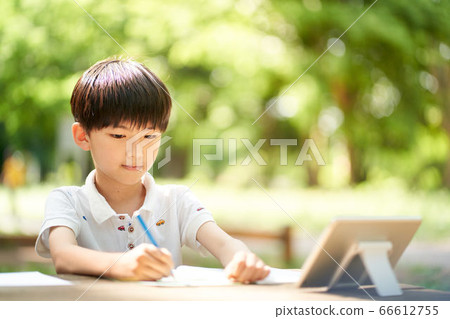 A boy studying outdoors while looking at the screen 66612755