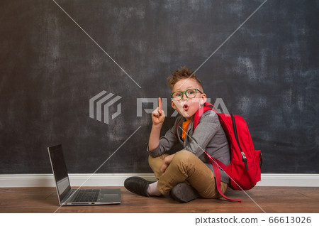 Portrait of little boy with laptop sitting on hardwood floor with finger up. Back to school. Portrait of little boy with laptop sitting on hardwood floor with finger up. Back to school. 66613026