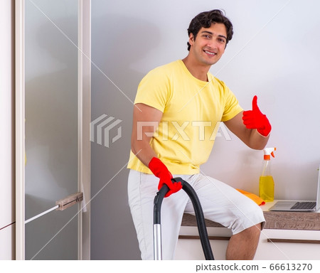 Young handsome man cleaning in the bedroom 66613270