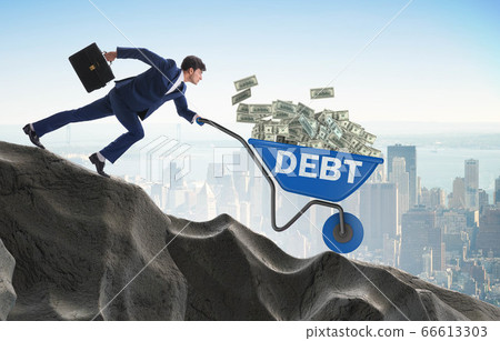 Businessman pushing wheelbarrow with dollars downhill Businessman pushing wheelbarrow with dollars downhill 66613303