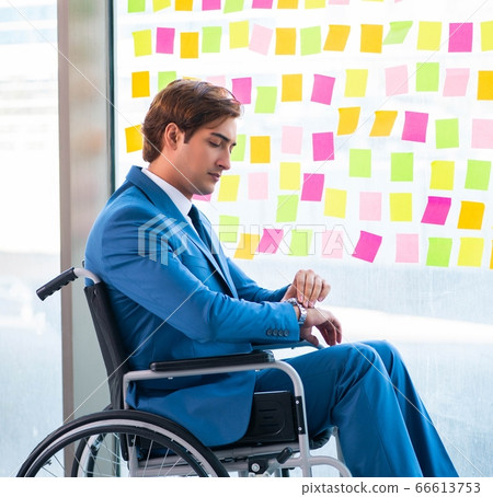 Young handsome man in wheelchair with many conflicting prioritie Young handsome man in wheelchair with many conflicting prioritie 66613753