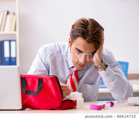 Man with first aid kit in the office 66614710