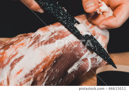 The chef of the restaurant in a dark uniform cuts 66615011