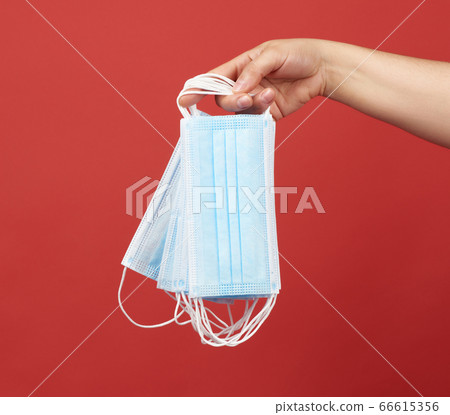 female hand holds a stack of disposable medical female hand holds a stack of disposable medical 66615356