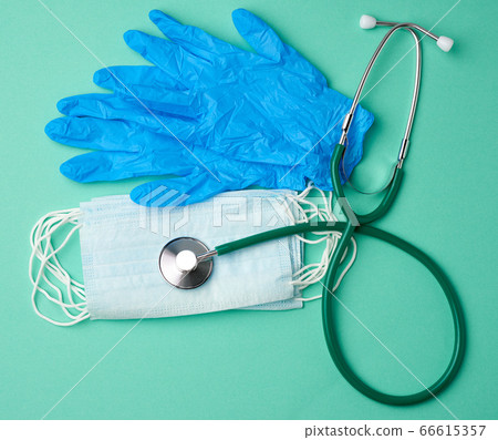 blue latex gloves and disposable masks on a green blue latex gloves and disposable masks on a green 66615357