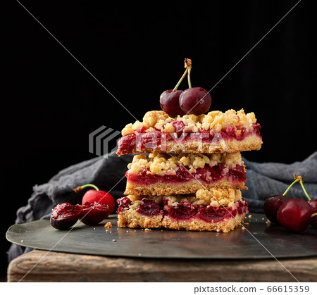 stack of square slices of a pie with red cherry, 66615359