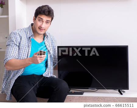 Man trying to fix broken tv Man trying to fix broken tv 66615511