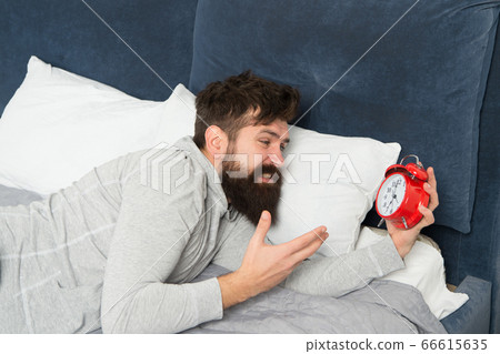 Too early. bearded man hate alarm clock while Too early. bearded man hate alarm clock while 66615635