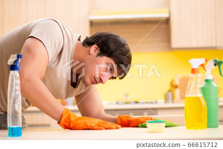 Single man cleaning kitchen at home Single man cleaning kitchen at home 66615712