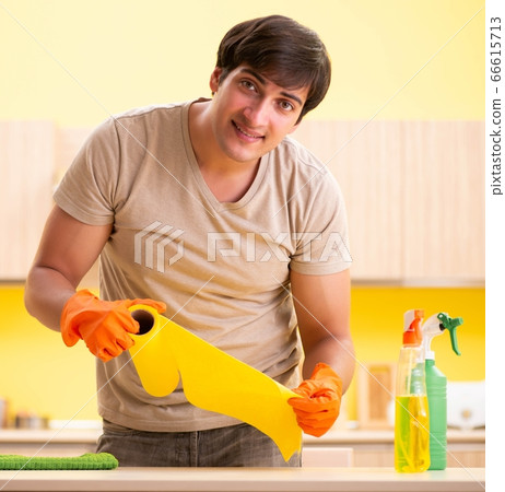 Single man cleaning kitchen at home Single man cleaning kitchen at home 66615713