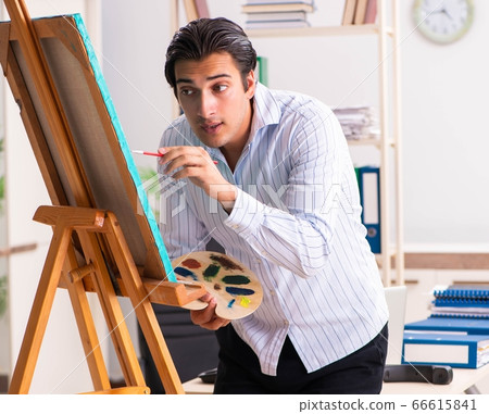 Young handsome employee enjoying painting at the office 66615841