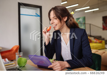 Joyful girl eating a lunchbox fork with vegetables Joyful girl eating a lunchbox fork with vegetables 66616249