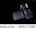 Top view professional digital camera with a zoom lens and a leather strap on a black background with copy space. View from above. Realistic 3d render. Place for advertising text. Reflection at bottom 66617166