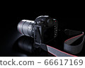 Professional digital SLR photo camera with a zoom lens and a leather strap on a black background with copy space. Top angle view. Realistic 3d render. Place for advertising text. Reflection at bottom 66617169