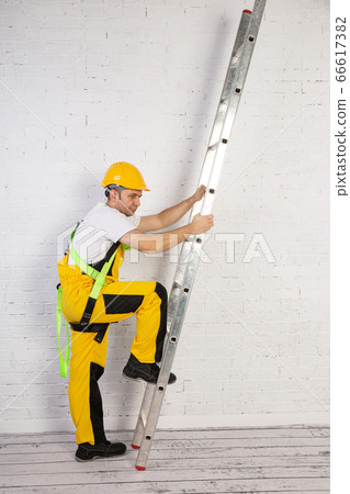 A professional builder with a ladder, compact and A professional builder with a ladder, compact and 66617382