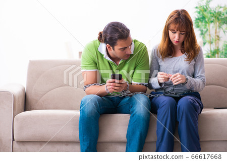 Young couple in gadget dependency concept 66617668