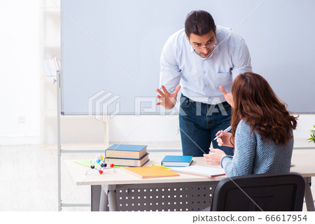 Young female student and male teacher in the classroom Young female student and male teacher in the classroom 66617954
