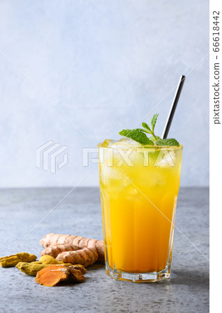 Glass of golden turmeric iced latte. Ayurvedic beverage. Glass of golden turmeric iced latte. Ayurvedic beverage. 66618442