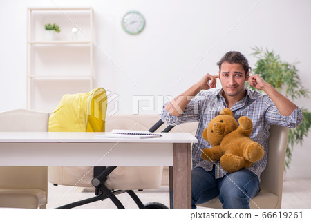 Young father looking after newborn baby at home 66619261