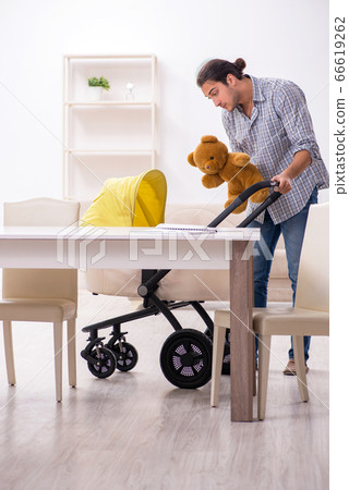 Young father looking after newborn baby at home 66619262