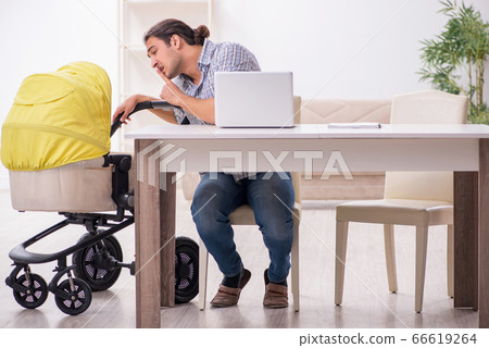 Young father looking after newborn baby at home 66619264