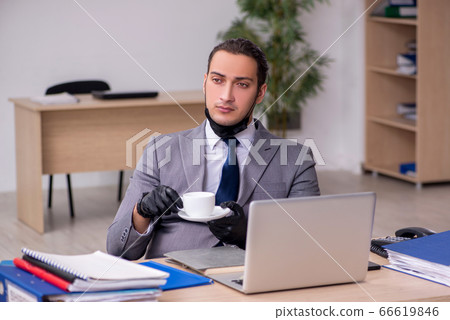 Young male employee in the office during pandemic disease Young male employee in the office during pandemic disease 66619846