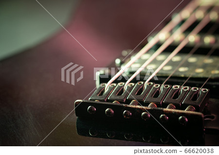 Rust bridge serves to fasten or tighten the string. Black vintage electric guitar in dark. Closeup and copy space. Concept of good memory About retro musical instruments and rock music. 66620038