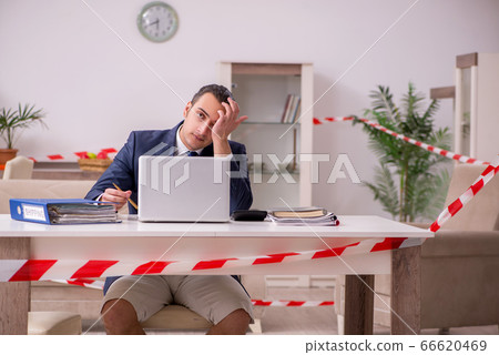 Young male employee working at home during pandemic disease 66620469