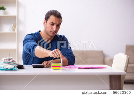 Young man in budget planning concept 66620500