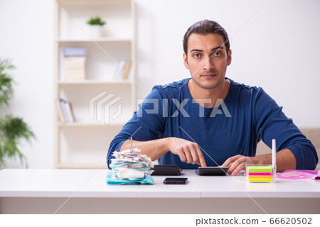 Young man in budget planning concept 66620502