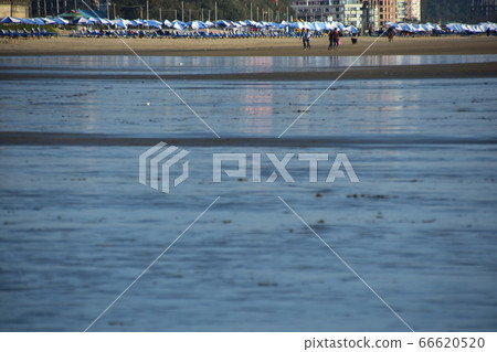 Cox's Bazar in Bangladesh A resort hotel along the beach and parasols lined up on the sandy beach People enjoying the beach Cox's Bazar in Bangladesh A resort hotel along the beach and parasols lined up on the sandy beach People enjoying the beach 66620520