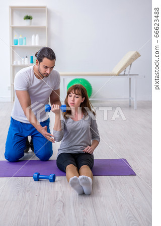 Young woman doing sport exercises with personal coach 66623488