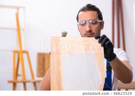 Young male contractor working in workshop Young male contractor working in workshop 66623529