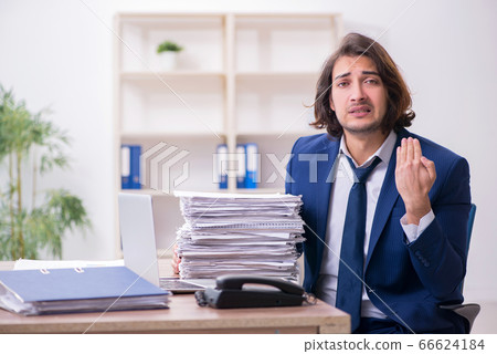 Young male employee unhappy with excessive work 66624184