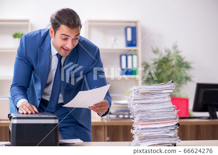 Young male employee making copies at copying machine Young male employee making copies at copying machine 66624276