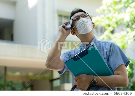 Middle-aged man wearing a mask and working outdoors [Researcher] 66624309