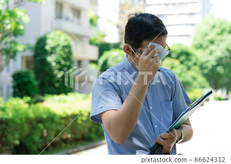 Middle-aged man wearing a mask and working outdoors [Researcher] 66624312