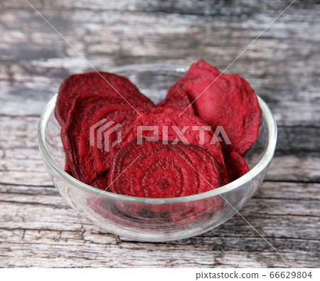Dried beets in a glass cup on a wooden background Dried beets in a glass cup on a wooden background 66629804