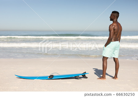 African American man and surf board on the beach African American man and surf board on the beach 66630250