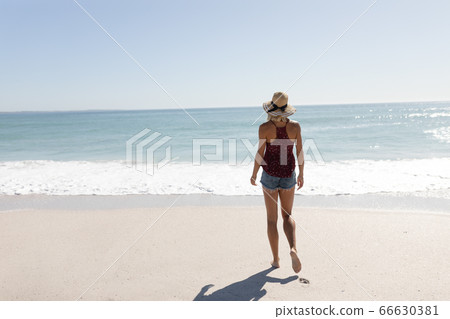 Caucasian woman standing on the beach 66630381