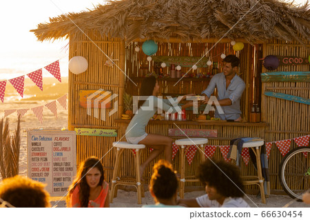 Mixed race friends group having fun on beach 66630454