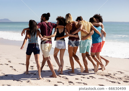Multi-ethnic group of male and female standing on the beach Multi-ethnic group of male and female standing on the beach 66630499