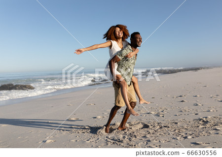 Happy couple spending time together on the beach Happy couple spending time together on the beach 66630556