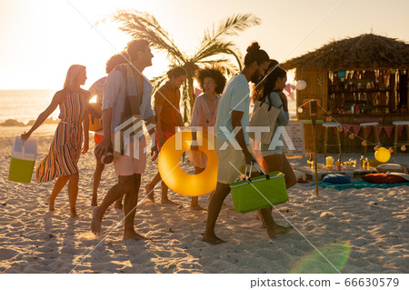 Mixed race friends group walking on beach Mixed race friends group walking on beach 66630579