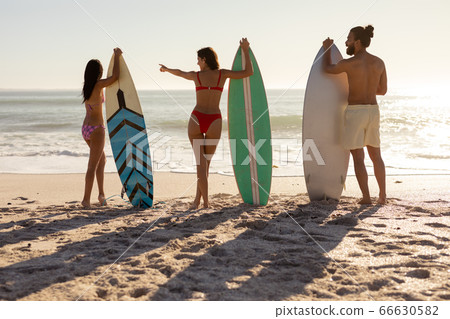 Multi-ethnic group of male and female, surfing on the beach Multi-ethnic group of male and female, surfing on the beach 66630582