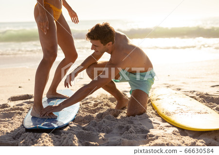 Young couple surfing on a beach Young couple surfing on a beach 66630584